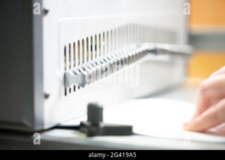 Femme anonyme travaillant sur la machine de reliure de livre Banque D'Images