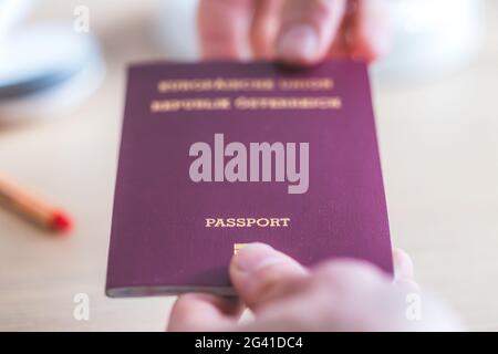 Passeport concept de vacances: Gros plan des doigts portant un passeport, d'arrivée ou de départ, â€œpassportâ€ Banque D'Images