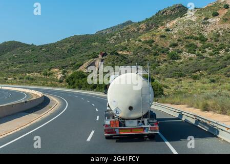 Camion-citerne avec marchandises dangereuses circulant sur la route avec des étiquettes de danger pour les produits toxiques. Banque D'Images