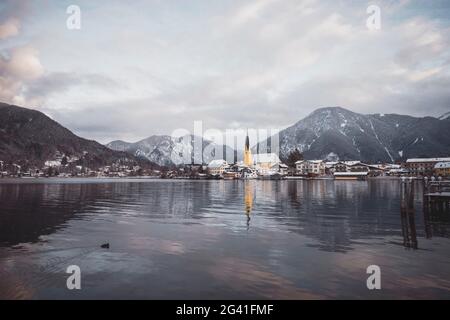 Vue sur le vivier Tegernsee jusqu'au village de Rottach-Egern avec l'église Sankt Laurentius, Bavière, Allemagne. Banque D'Images