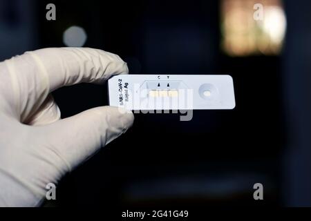 Un personnel médical montre un résultat positif du test AG rapide du SRAS-COV-2 et du test positif du virus corona Covid-19 sur un fond flou, nouvelle pandémie c Banque D'Images