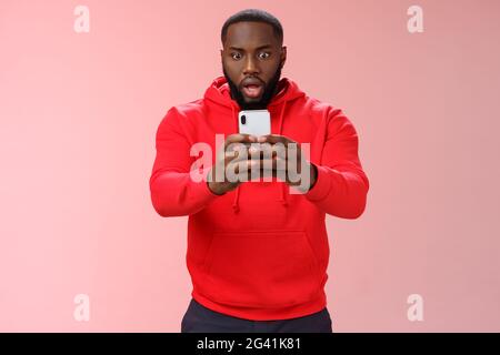 Eh bien, ne lâchons pas la prise de vue. Portrait impressionné surpris surpris homme choqué de capturer une situation choquante tenant le smartphone disp Banque D'Images
