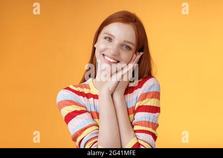 Adorable jeune fille européenne flirty redhead souriant largement excité heureux palmier maigre recevoir doux tendre présent look reconnaissant amu Banque D'Images