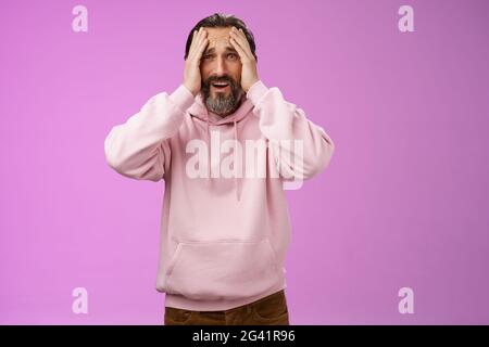 Adulte bouleversé barbu homme désespéré debout troublé préoccupé touchant le visage froning grimacing tristesse unhapping, perdant pari, était Banque D'Images