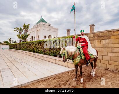 Garde royale sur un cheval en face de la Tour Hassan et du mausolée de Mohammed V, Rabat, région Rabat-sale-Kenitra, Maroc Banque D'Images