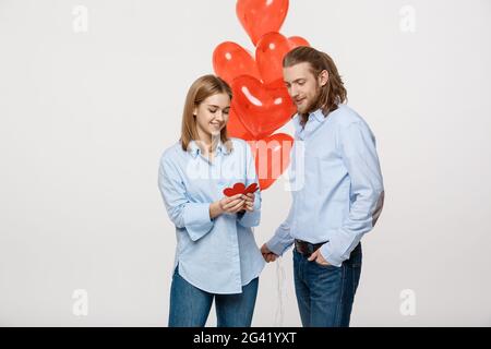 Conception agréable jeune couple holding heart balloon et papier. Banque D'Images