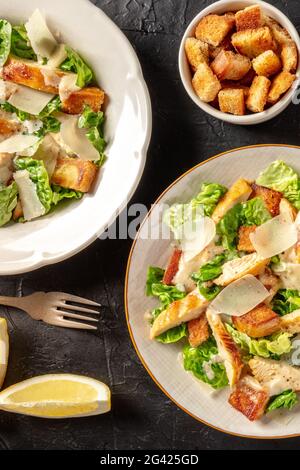 Salade César au poulet, prise du dessus avec des croûtons et des citrons Banque D'Images