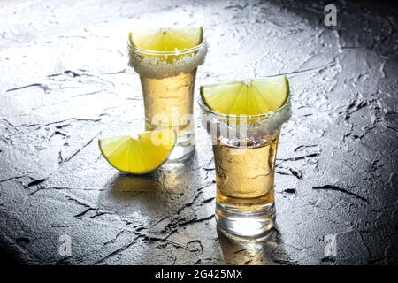 Doses de Tequila avec bords salés et tranches de lime Banque D'Images