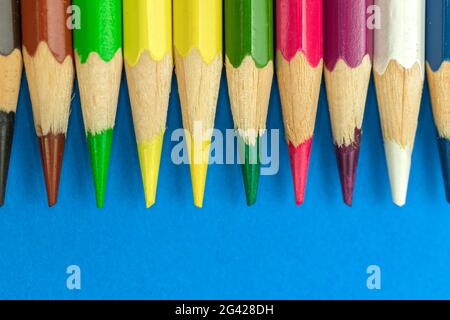 Gros plan sur des crayons de couleur nets, des photographies macro, un arrière-plan bleu Banque D'Images