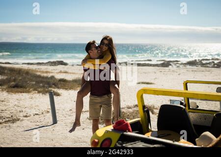 Couple de caucasiens heureux à côté de la plage buggy au bord de la mer support de porc Banque D'Images