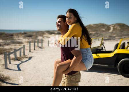 Couple de caucasiens heureux à côté de la plage buggy au bord de la mer support de porc Banque D'Images