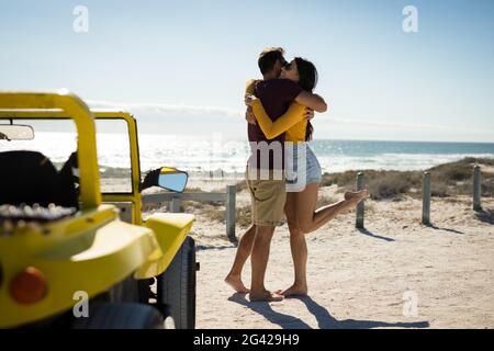 Bon couple de caucasiens séjournant à côté de la promenade sur la plage la mer embrasse Banque D'Images