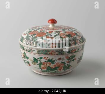 Turen avec sprays de fleurs, papillon et poisson. Terrine ronde de porcelaine, peinte sur le glaçure en bleu, rouge, vert, jaune, aubergine, noir et or. L'extérieur du bol avec de grandes branches de fleurs (pivoine, chrysanthème); sur le bord d'une bande avec une serviette de table avec une fleur de pivoine parsemée de crevettes ou de poissons dans une cartouche; une branche de piona avec un papillon au fond; Le bord avec un lien avec le motif de fleur, avec un lien de motif ruyi ci-dessous. Famille verte. Banque D'Images