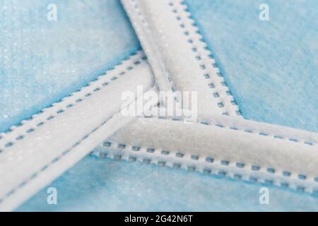 Les masques jetables de protection médicale sont empilés sous la forme d'un panneau de recyclage. Macro. Concept de conservation de l'environnement. Symbole de recyclage. Sélectif Banque D'Images