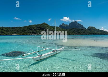 Canoë-kayak sur la plage au Sofitel Bora Bora Private Island Resort dans le lagon de Bora Bora avec le Mont Otemanu au loin, Bora Bora, Leeward Banque D'Images