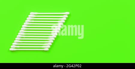 Bâtonnets de coton/écouvillons disposés en trapèze sur une table verte, vue du dessus, espace pour le texte du côté droit Banque D'Images