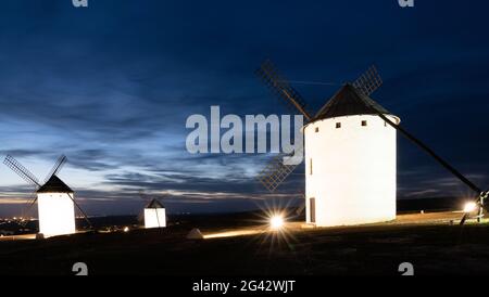 Vue sur les moulins à vent blancs historiques de la Mancha au-dessus de la ville de Campo de Criptana au coucher du soleil Banque D'Images