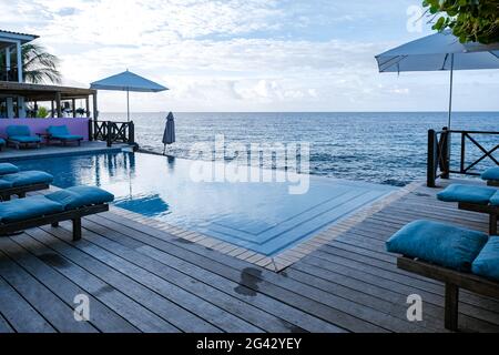 Plage d'été reposante, terrasse pour bronzer et piscine privée avec palmiers près de la plage et vue panoramique sur la mer au luxe ho Banque D'Images