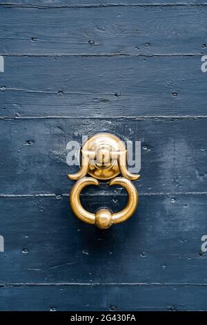 Ancienne poignée de porte en dorure sur une porte en bois bleu. Banque D'Images