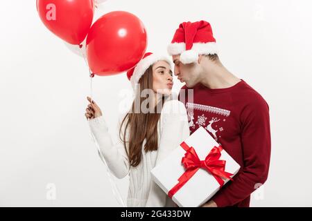 Concept de Noël - jeune amie holding balloon est hugging et jouant avec son petit ami de faire une surprise à Noël Banque D'Images