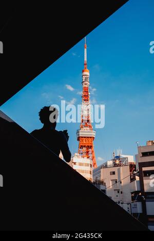 Siluette d'un touriste photographiant la Tour de Tokyo avec son téléphone portable, Tokyo, Japon Banque D'Images