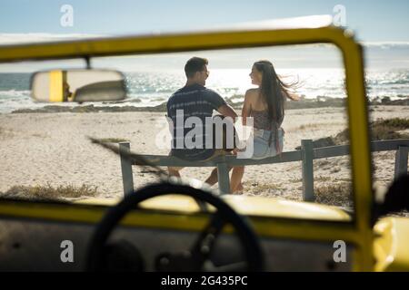 Couple de caucasiens heureux à côté de la plage buggy au bord de la mer jouer de la guitare Banque D'Images