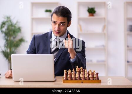 Un jeune homme jouant aux échecs sur le lieu de travail Banque D'Images