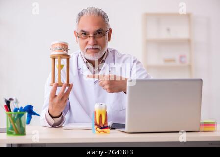 Ancien dentiste masculin dans le concept de gestion du temps Banque D'Images