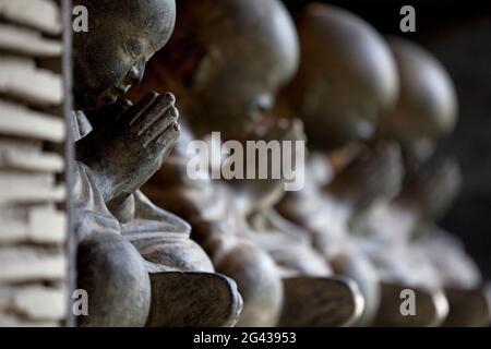 Une rangée de statues de Bhudda en béton poli. Bali Banque D'Images