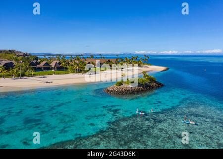 Vue aérienne de la famille appréciant les activités nautiques à côté de la petite île barrière à six Senses Fiji Resort, Malolo Island, Mamanuca Group, Fidji Isl Banque D'Images