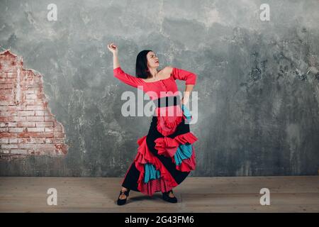 Jeune femme espagnole adulte dansant le flamenco sur fond gris vintage Banque D'Images