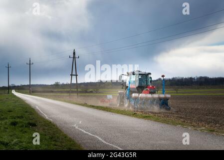 Tracteur sur une récolte d'ensemencement de champ Banque D'Images