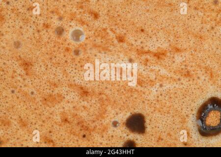 Gros plan sur la mousse au chocolat chaud, macro. Arrière-plan abstrait. Café noir avec texture mousse de crème de lait. Gros plan café espresso noir, vue de dessus. Gros plan Banque D'Images