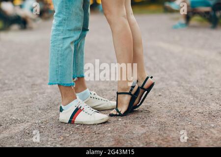 Histoire d'amour. Jeune femme et homme assis sur le banc. Elle le touche. Banque D'Images