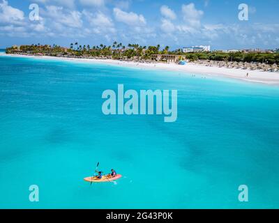 Couple kayak dans l'océan sur les vacances Aruba mer des Caraïbes, homme et femme kayak à mi-âge dans l'eau de la clrea bleu océan Banque D'Images