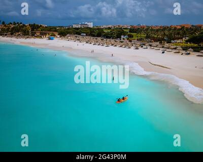 Couple kayak dans l'océan sur les vacances Aruba mer des Caraïbes, homme et femme kayak à mi-âge dans l'eau de la clrea bleu océan Banque D'Images