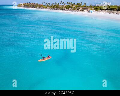 Couple kayak dans l'océan sur les vacances Aruba mer des Caraïbes, homme et femme kayak à mi-âge dans l'eau de la clrea bleu océan Banque D'Images