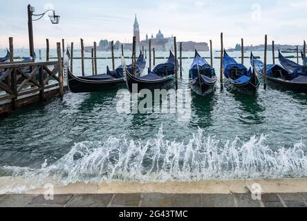 Vue sur les gondoles vénitiennes sur la place Saint-Marc avec spray, en arrière-plan l'île de San Giorgio, Venise, Vénétie, Italie, Europe Banque D'Images