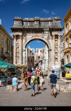 Piétons et l'ancienne arche romaine du Sergii dans le centre de la vieille ville, Pula, Istrie, Croatie, Europe Banque D'Images