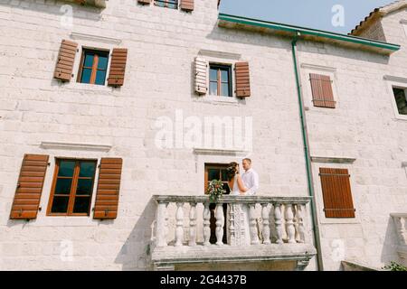 La mariée et le marié embrassent sur le grand balcon de Un ancien bâtiment dans la ville ancienne du Monténégro Banque D'Images