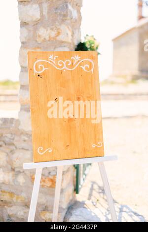 Chevalet en bois vierge avec des monogrammes près d'une colonne en pierre sur un support Banque D'Images