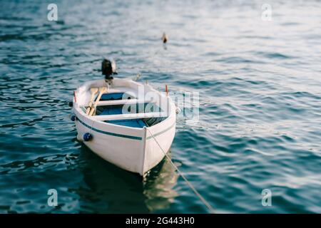 Bateau de pêche en bois blanc avec bâbord et moteur. Banque D'Images