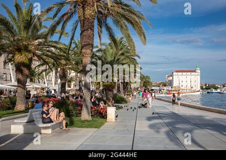 Personnes profitant du soleil le long de la promenade avec des palmiers, Split, Split-Dalmatie, Croatie, Europe Banque D'Images