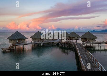 Vue aérienne sur les bungalows sur l'eau du Tahiti IA ora Beach Resort (géré par Sofitel) au coucher du soleil, près de Papeete, Tahiti, Iles du vent, Pô français Banque D'Images