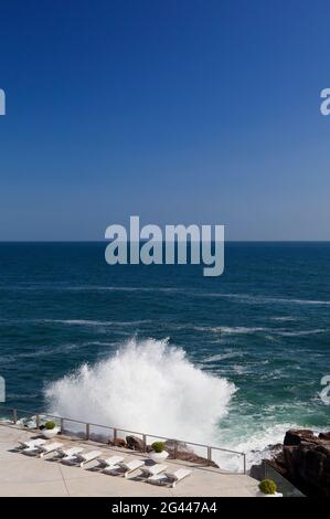 Une énorme pause contre une terrasse de piscine avec une vue sur l'océan, tourné près de Cascais au Portugal. Banque D'Images