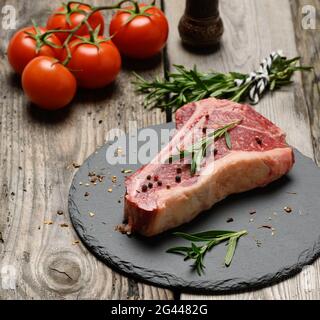 Morceau de boeuf frais, steak de striploin sur un tableau noir avec épices Banque D'Images