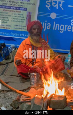 BABUGHAT, KOLKATA, BENGALE-OCCIDENTAL / INDE - 9th JANVIER 2018 : Indien hindou Sadhu , chant des chansons religieuses au camp de transit de Gangasagar. Lumière colorée, Banque D'Images