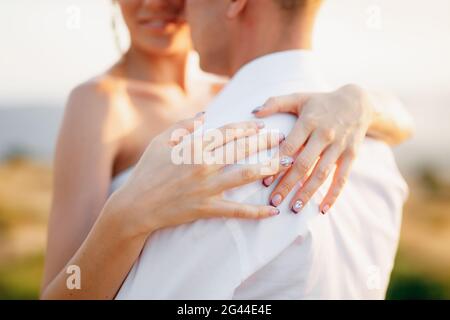 La mariée et le marié câlin, la mariée a mis ses mains sur l'arrière du marié, gros plan Banque D'Images