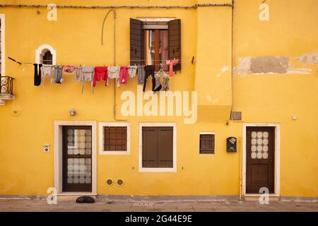 Vue sur une façade de maison jaune avec des vêtements à Cannaregio, Venise, Vénétie, Italie, Europe Banque D'Images