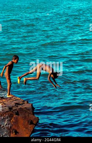 20 mai 2002-Dili, Timor-Leste-in photos prises scène du jour de l'indépendance et vie quotidienne timoraise le 7 jour à Dili et Atambua Village. Les enfants jouent à la plongée sur le bateau à couronne de la baie de Dili, au Timor-Leste. Banque D'Images